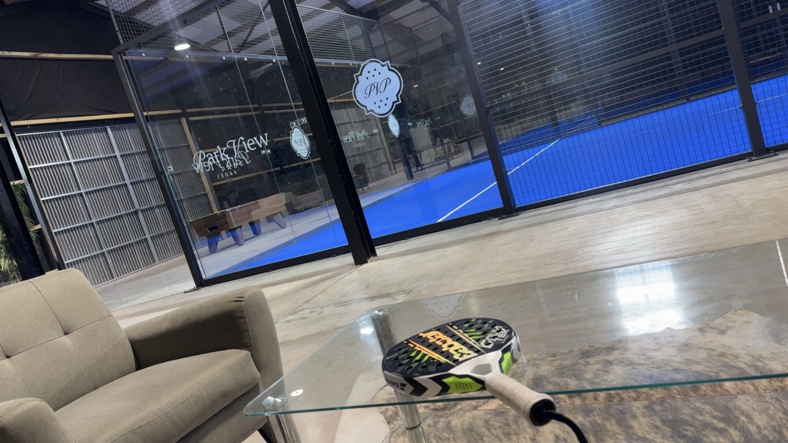 Padel court at Park View Padel with a racket on a glass table